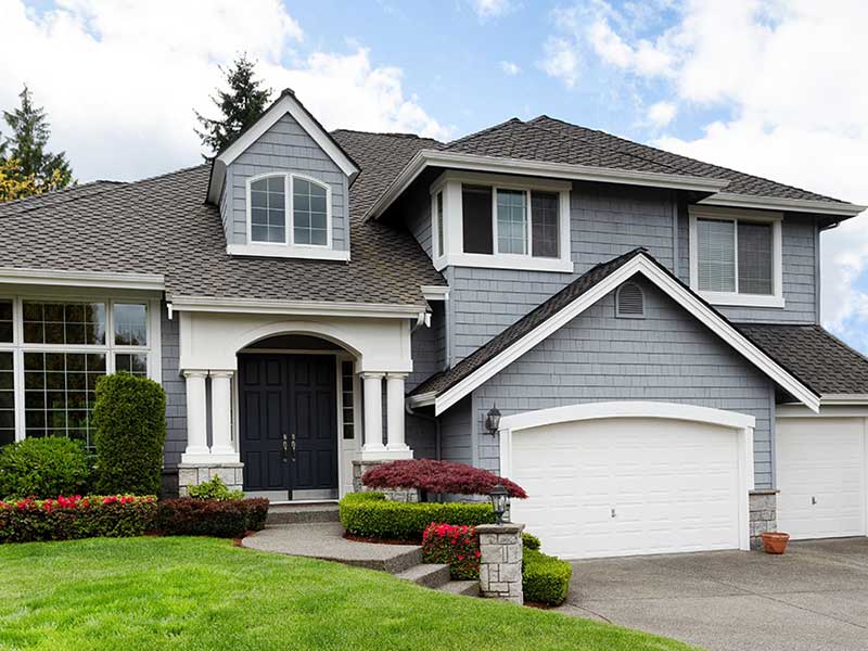 Front view of a home with a gray shingle roof and blue siding